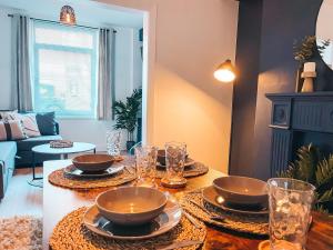 a living room with a table with dishes on it at Hamilton House by Solace Stays in Merthyr Tydfil
