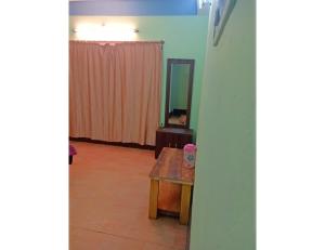 a living room with a wooden table and a mirror at Cherry Village Resort, Pelling, Sikkim in Pelling