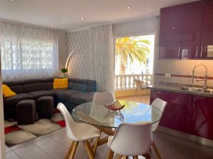 een woonkamer met een glazen tafel en een bank bij Relax and enjoy with a view of El Teide and sea in Puerto de Santiago