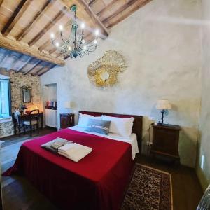 a bedroom with a large bed with a red blanket at B&B Podere Camaiano in Roccastrada