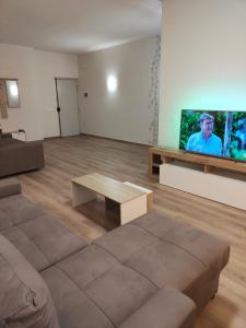 uma sala de estar com um sofá e uma televisão de ecrã plano em Wagner house em Acireale
