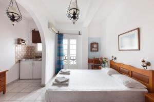 a bedroom with a large bed and a kitchen at DELFINI I in Fira