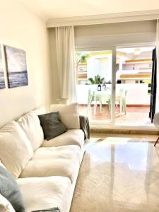 米哈斯科斯塔的住宿－Wonderful appartement on golf site near Marbella，客厅配有白色的沙发和桌子