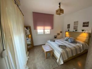 um quarto com uma cama e uma cadeira em Casa Annie em Loutraki