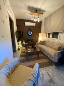 uma sala de estar com um sofá e uma mesa em Casa Annie em Loutraki