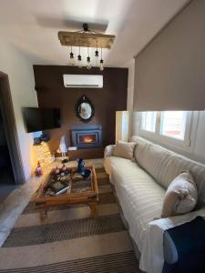 Casa Annie في لوتراكي: غرفة معيشة مع أريكة ومدفأة