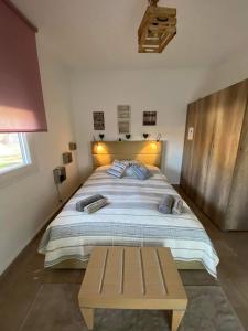 - une chambre avec un grand lit et un banc en bois dans l'établissement Casa Annie, à Loutraki