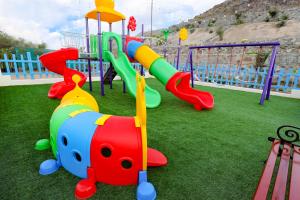 a playground with a slide and a play equipment at Red_Hut_Resort in Hatta