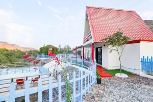 a house with a white fence and a pool at Red_Hut_Resort in Sharīyah