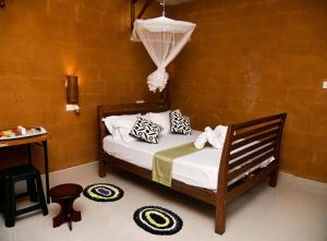 1 dormitorio con 1 cama y 1 mesa con silla en Clay House, en Udawalawe