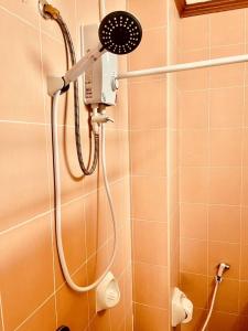une douche avec pommeau de douche dans une salle de bain dans l'établissement Innarm House Patong, à Patong Beach