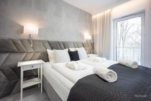 Dos camas en una habitación de hotel con toallas. en Apartament z kominkiem.. and SPA, MyWeek, en Polanica-Zdrój