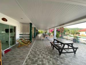 un patio con bancos y mesas en un edificio en Winnerview Zone B, en Koh Larn