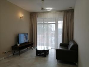 a living room with a couch and a television at City Tropical Home I in George Town