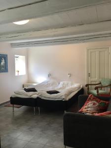 um quarto com duas camas e um sofá em Vita og Pouls Gård - Guesthouse em Viby