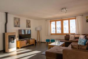 a living room with a couch and a television at Schützenrain 1. Stock in Adelboden