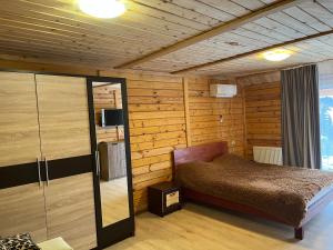 ein Schlafzimmer mit einem Bett in einem Zimmer mit Holzwänden in der Unterkunft Belvedere-Karpaty-Panorama in Schidnyzja