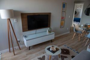 a living room with a flat screen tv on a wall at Ap Cozy Calhau prox PRAIA in São Luís