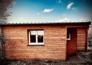 a small wooden building with a window on it at Home Studio in Poses +3 photos