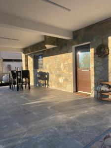 un patio con sillas y una pared de piedra. en DIAMOND Stone Wooden Guest House, en Khandria