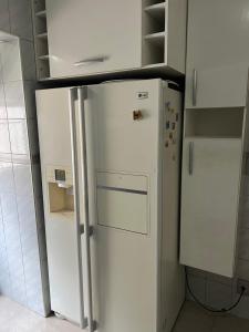 a white refrigerator in a kitchen next to cabinets at Apartamento Familiar em Campinas 9 solteiros ou 10 se 2 pessoas na cama de casal in Campinas