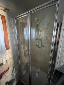 a shower stall with a toilet in a bathroom at Sèn jan apartment 150 mt dalle piste in Pozza di Fassa