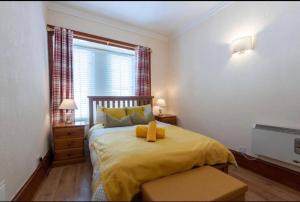 a bedroom with a bed with yellow sheets and a window at Georges57 2-Bed Apartment in Inverness in Inverness