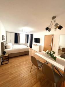 a living room with a bed and a table and chairs at Park-Residenz Isernhagen in Hannover