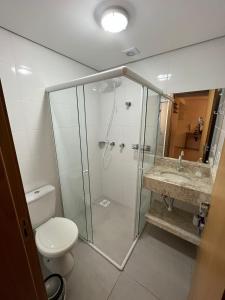 a bathroom with a shower and a toilet and a sink at Apartamento em Torres in Torres