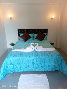 a blue bed with two white towels on it at Funky Crab The River in Krabi town