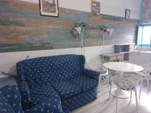 a living room with a blue couch and a table at Casa Violette in Almería