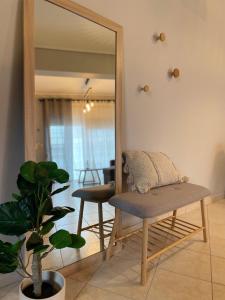 lustro w pokoju z ławką i krzesłem w obiekcie Filoxenia - Ολόκληρο διαμέρισμα w mieście Wolos