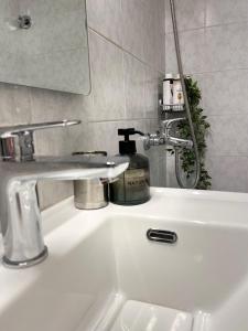 biała umywalka z kranem w łazience w obiekcie Filoxenia - Ολόκληρο διαμέρισμα w mieście Wolos