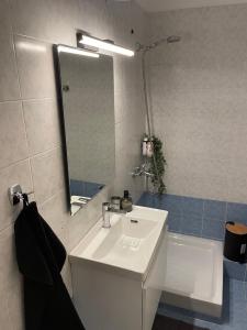 W łazience znajduje się umywalka, lustro i wanna. w obiekcie Filoxenia - Ολόκληρο διαμέρισμα w mieście Wolos