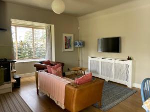 ein Wohnzimmer mit einem Sofa und einem TV in der Unterkunft Princeland Lodge in Blairgowrie