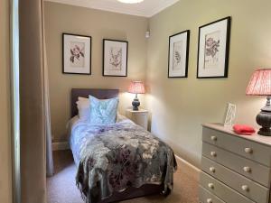 a bedroom with a bed and two lamps and a dresser at Princeland Lodge in Blairgowrie