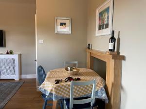 a dining room with a table and a bottle of wine at Princeland Lodge in Blairgowrie