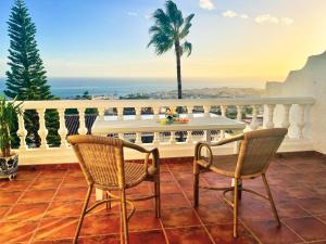 a balcony with a table and chairs and a view of the ocean at Casa Yaya Nerja in Nerja