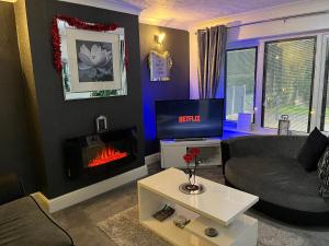 sala de estar con sofá y chimenea en The Brook House - Spacious 3 Bed Home From Home en Burton upon Trent