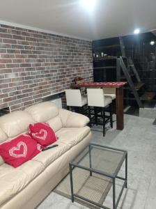 Apartment parking loft Akaciju في فيلنيوس: غرفة معيشة مع أريكة وطاولة