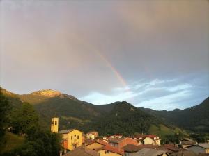 a rainbow in the sky over a town with mountains at La dimora degli Angeli in Moggio