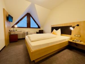 a bedroom with a large bed with a large window at Hotel Zur Linde in Lauf