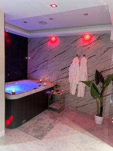 a large bathroom with a blue tub in a room at NUITS D'HERMES & Spa in Chalon-sur-Saône