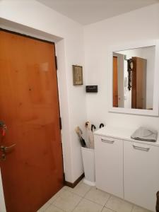 a bathroom with a door and a mirror at La dimora degli Angeli in Moggio