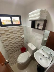 a bathroom with a white toilet and a sink at Ma Lourdes Inn- Washington Street in Palompon