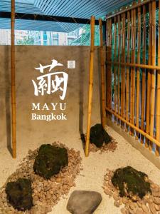 MAYU Bangkok Japanese Style Hotel في بانكوك: يوجد لافتة لماريوا بانكوك وعليها صخور