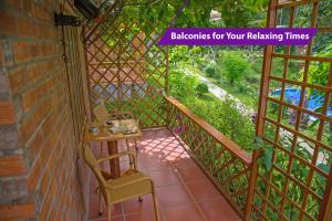 Habitación con balcón con mesa y silla. en Sim Bungalow en Phu Quoc