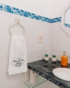 een badkamer met een witte handdoek aan de muur bij Miau de Pipa in Pipa