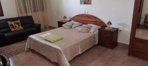 um quarto com uma cama grande e um sofá em Residencial Chez Flor em Porto Novo