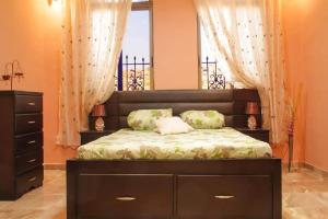 a bedroom with a bed and a dresser and a window at Khirfan Crown Houses -downtown in Amman